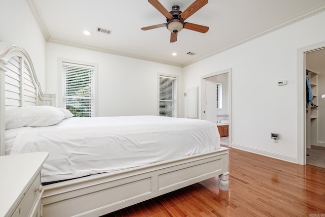 bedroom featuring ceiling fan, ensuite bathroom, ornamental molding, and light hardwood / wood-style floors