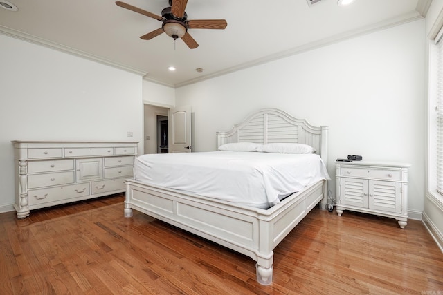 bedroom with ceiling fan, hardwood / wood-style floors, and crown molding