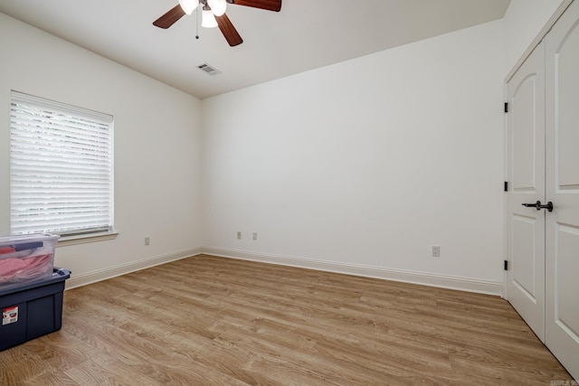 empty room with ceiling fan and light hardwood / wood-style floors