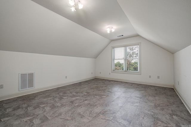 bonus room with tile patterned flooring and lofted ceiling