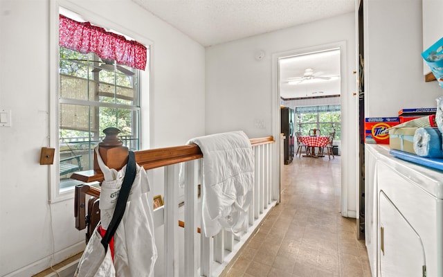 corridor with washer and clothes dryer and a textured ceiling