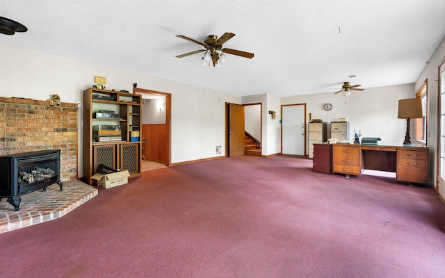 living room with ceiling fan, a textured ceiling, and dark colored carpet