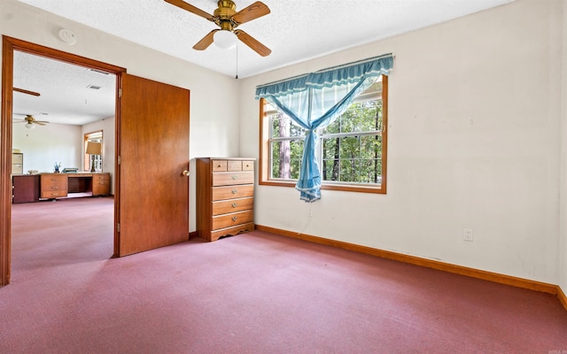 carpeted empty room with ceiling fan and a textured ceiling