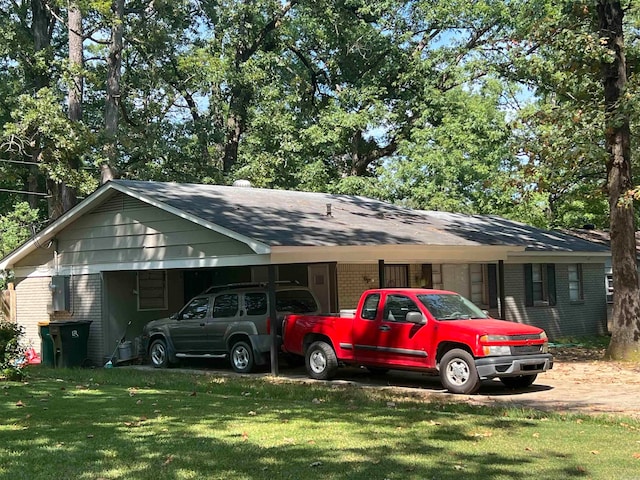 view of vehicle parking featuring a yard and a carport