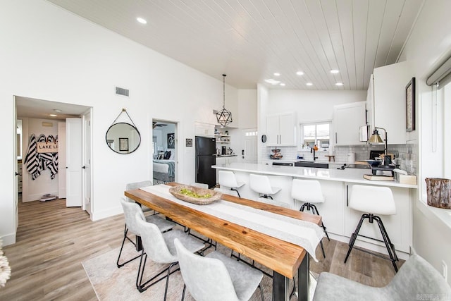 dining room featuring light wood-type flooring and lofted ceiling