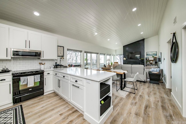 kitchen with lofted ceiling, light hardwood / wood-style floors, backsplash, black range with electric cooktop, and kitchen peninsula