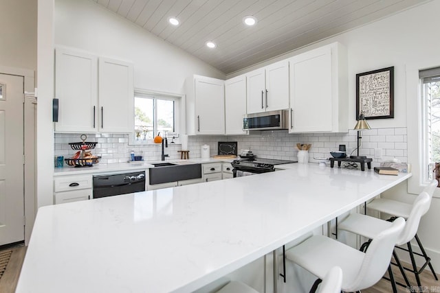 kitchen featuring decorative backsplash, electric stove, light wood-type flooring, and lofted ceiling