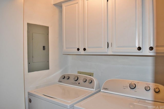 clothes washing area featuring washing machine and clothes dryer, cabinets, and electric panel