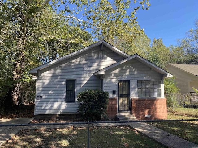 view of front of house with entry steps, crawl space, fence, and brick siding