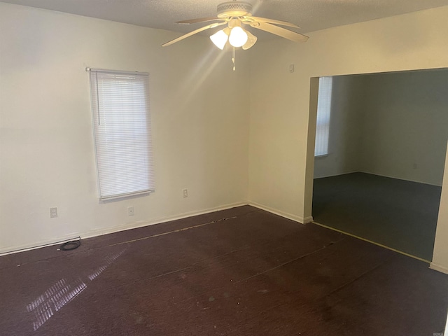 unfurnished room featuring ceiling fan and baseboards