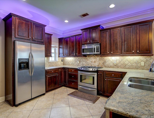 kitchen with appliances with stainless steel finishes, light tile patterned flooring, ornamental molding, tasteful backsplash, and sink