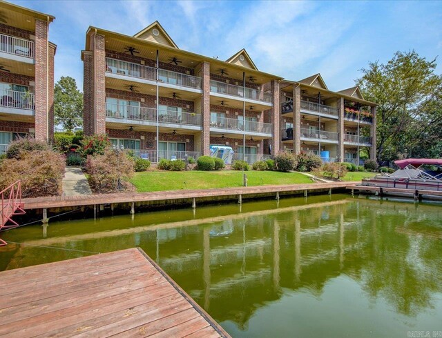 dock area with a water view and a balcony