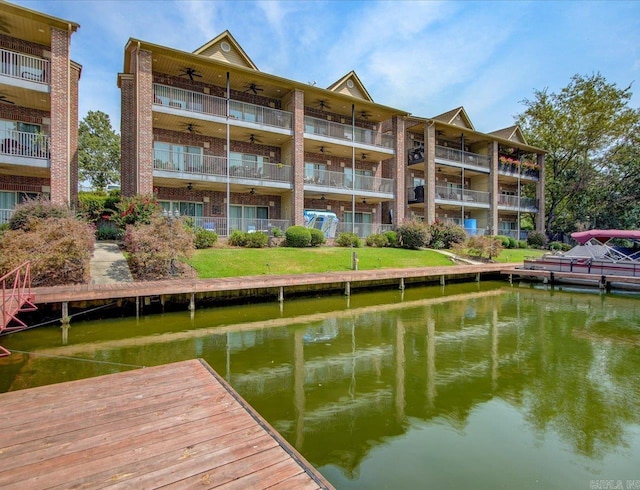 dock area with a water view and a lawn