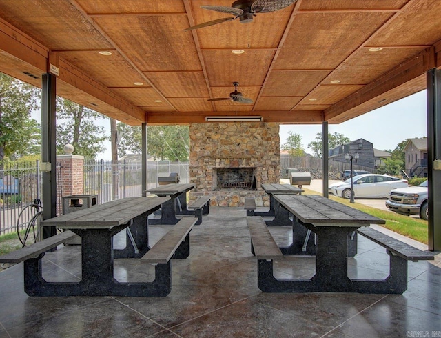 view of patio with an outdoor stone fireplace and ceiling fan