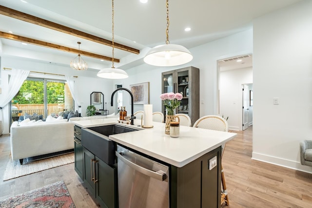 kitchen featuring hanging light fixtures, dishwasher, a center island with sink, and light hardwood / wood-style flooring