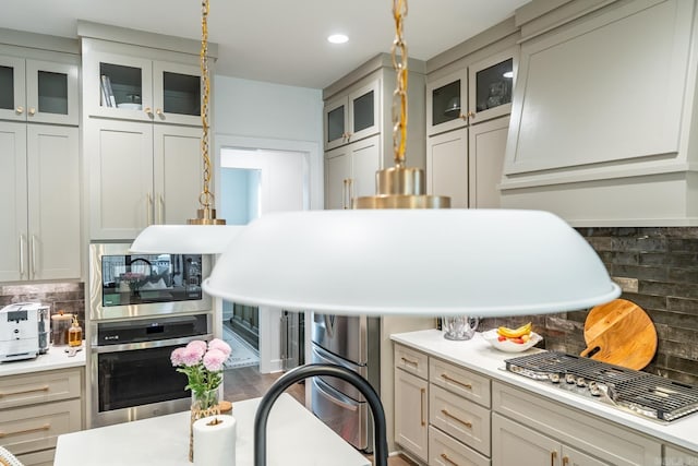 kitchen with stainless steel appliances, pendant lighting, and decorative backsplash