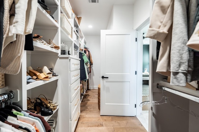 walk in closet with light wood-type flooring