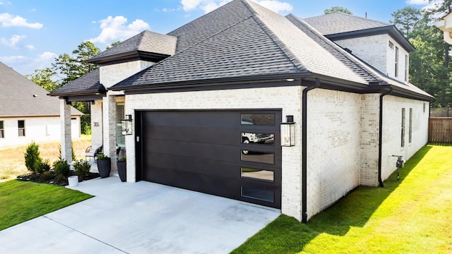 view of side of property featuring a yard and a garage