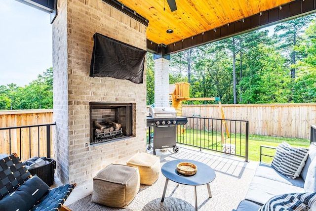 view of patio / terrace with a grill and an outdoor living space with a fireplace