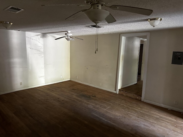 basement with a textured ceiling, wood finished floors, a ceiling fan, visible vents, and baseboards