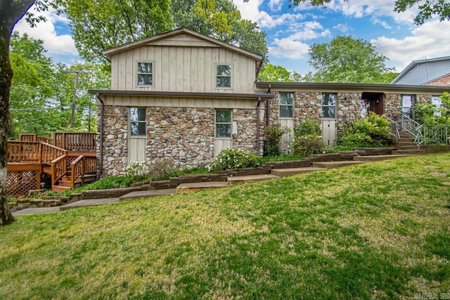 rear view of house featuring a wooden deck and a lawn