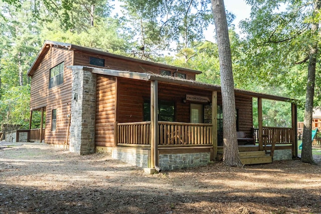 view of front of house with log veneer siding and driveway