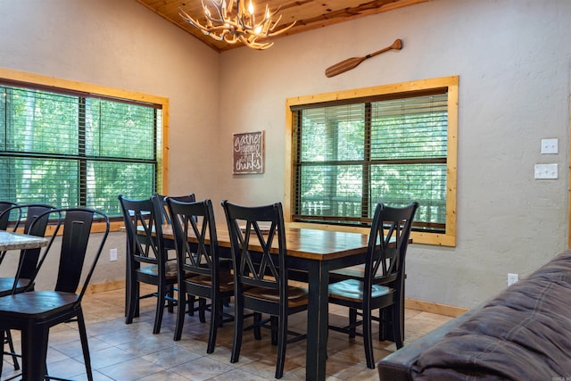 tiled dining area with a notable chandelier and vaulted ceiling