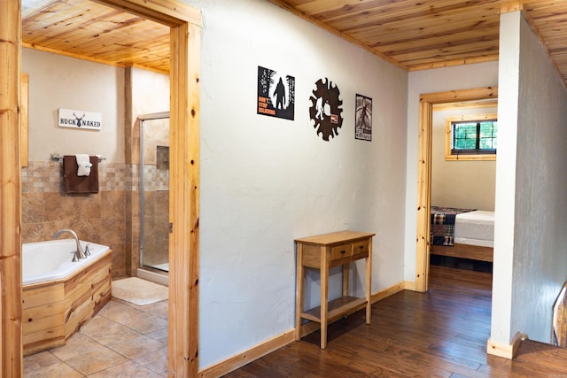 hallway with tile walls, wooden ceiling, and hardwood / wood-style floors