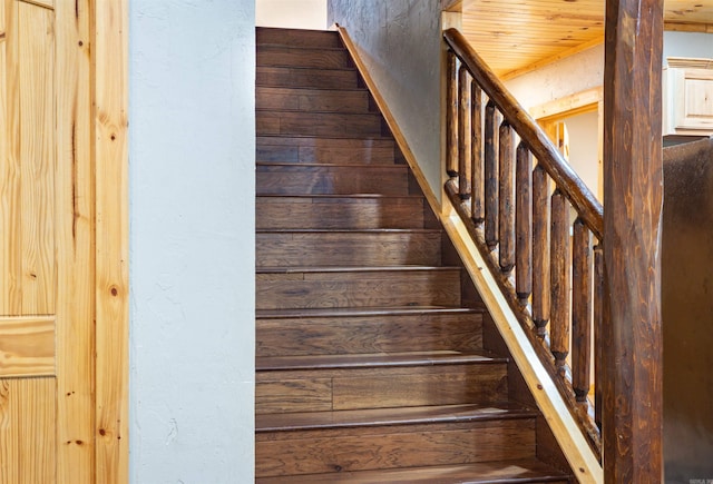 stairway featuring wood walls