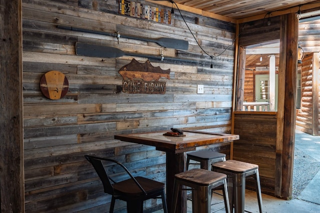 dining space featuring wooden ceiling and wooden walls