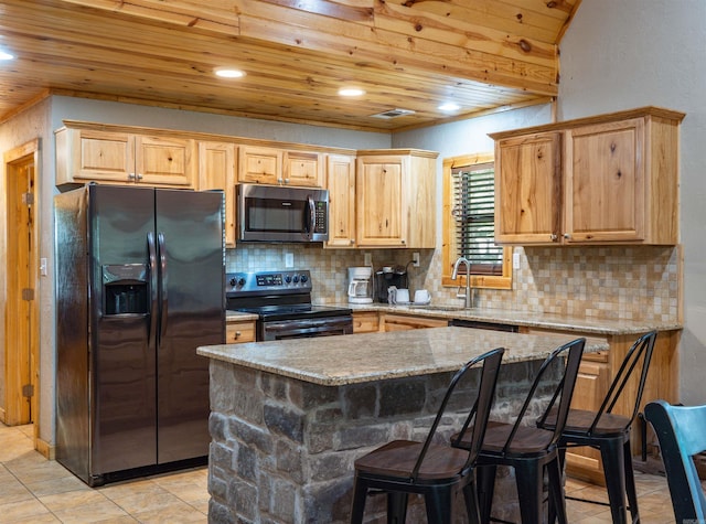 kitchen with tasteful backsplash, light tile patterned floors, black appliances, a kitchen island, and wood ceiling