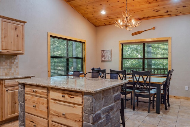 kitchen with light brown cabinets, wood ceiling, pendant lighting, a center island, and backsplash