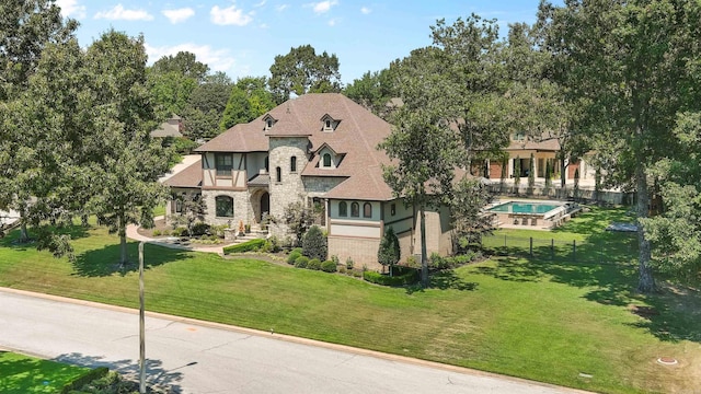 tudor home with a front lawn