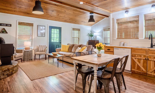 dining area with sink, light wood-type flooring, wood ceiling, and beam ceiling