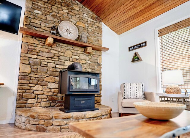 living room with hardwood / wood-style floors, ornamental molding, a wood stove, wooden ceiling, and lofted ceiling