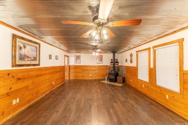 interior space with wood ceiling, ceiling fan, hardwood / wood-style flooring, and a wood stove