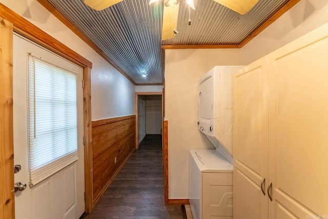 corridor with stacked washer / dryer, dark hardwood / wood-style flooring, wooden ceiling, and ornamental molding