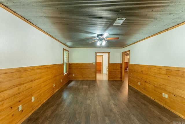 unfurnished room featuring ceiling fan, wooden walls, and dark hardwood / wood-style flooring