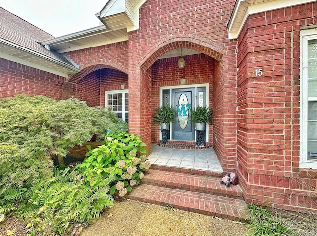 entrance to property featuring brick siding