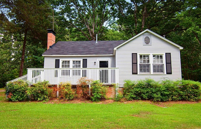 view of front of home featuring a front yard and a wooden deck