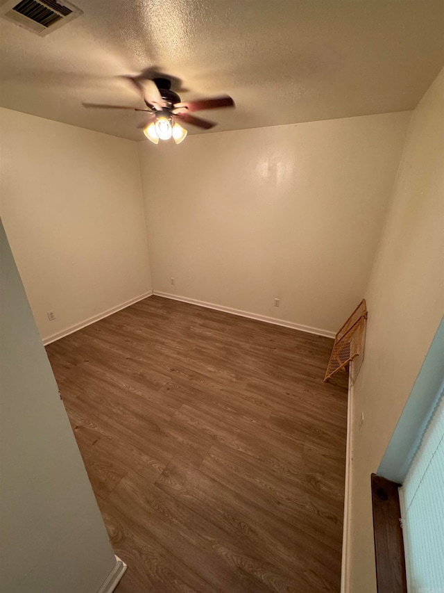 spare room featuring ceiling fan, hardwood / wood-style flooring, and a textured ceiling