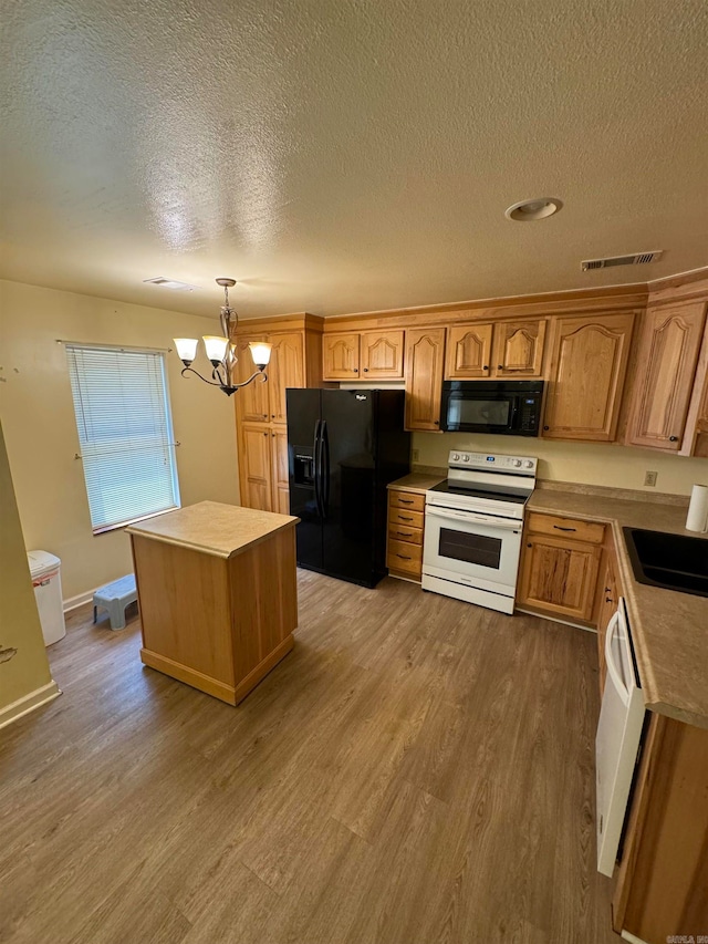 kitchen featuring light wood-type flooring, a chandelier, a textured ceiling, and black appliances