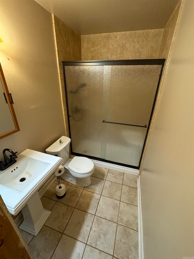 bathroom featuring toilet, walk in shower, and tile patterned flooring