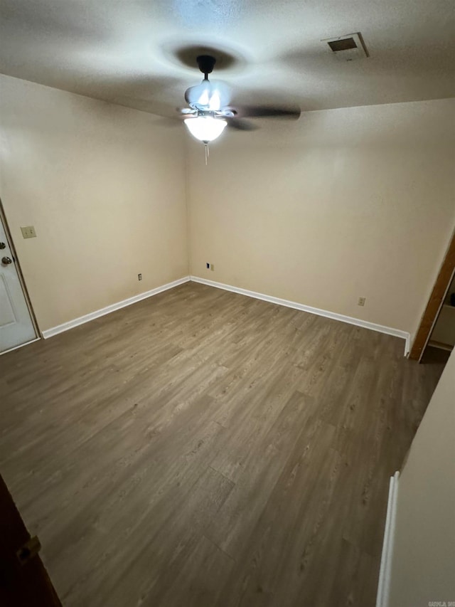 empty room with a textured ceiling, ceiling fan, and hardwood / wood-style floors