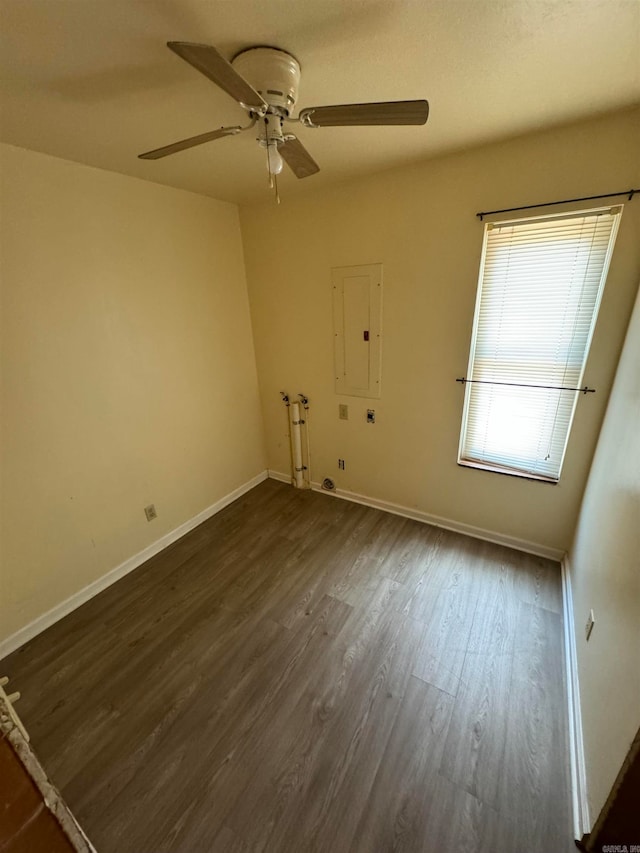 unfurnished room featuring ceiling fan, dark hardwood / wood-style floors, electric panel, and a wealth of natural light