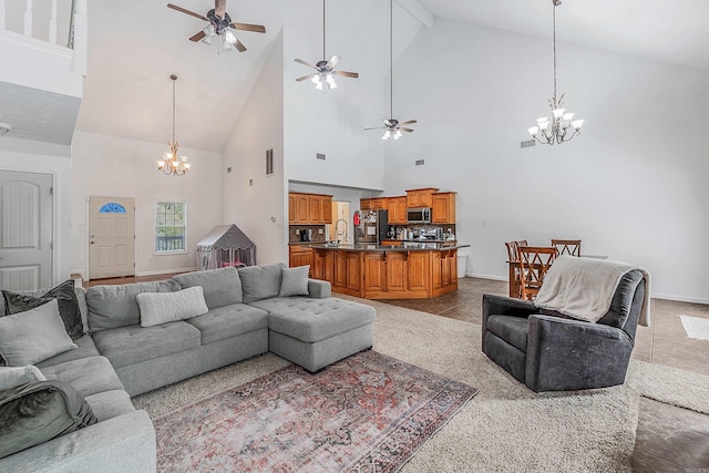 living room featuring ceiling fan with notable chandelier, high vaulted ceiling, sink, and tile patterned flooring