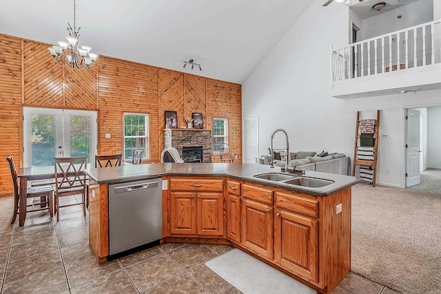 kitchen featuring dishwasher, carpet, sink, high vaulted ceiling, and a stone fireplace