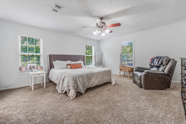 bedroom featuring carpet floors, ceiling fan, and multiple windows