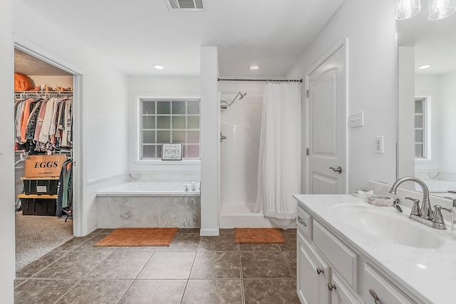 bathroom with a bathing tub, vanity, and tile patterned floors