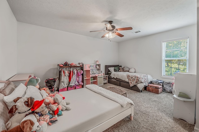 carpeted bedroom featuring a textured ceiling and ceiling fan